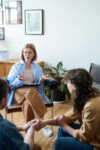 Mature psychotherapist talking to young couple at session, she discussing their problems and giving them advices