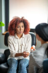 Listening to psychoanalyst. Curly woman listening to psychoanalyst recommending antidepressants