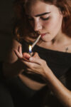 Young woman smoking marihuana at home