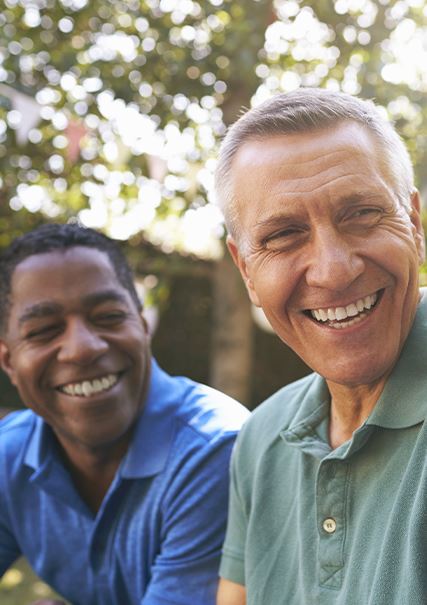 African American and Caucasian adult males smiling mid conversation