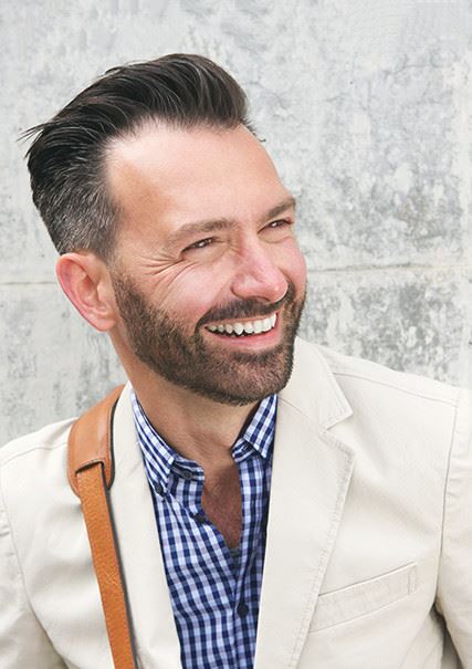 Adult caucasian male with slicked back hair smiling
