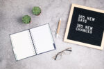 365 new days, 365 new chances. Letter board with motivational quote with notepad , pen, eye glasses and succulent. New yearâs resolutions mockup. Flatlay, top view