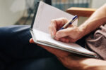 close-up-image-of-man-enjoying-moment-for-himself-and-filling-diary-after-difficult-day-stockpack-gettyimages-1-1200x800