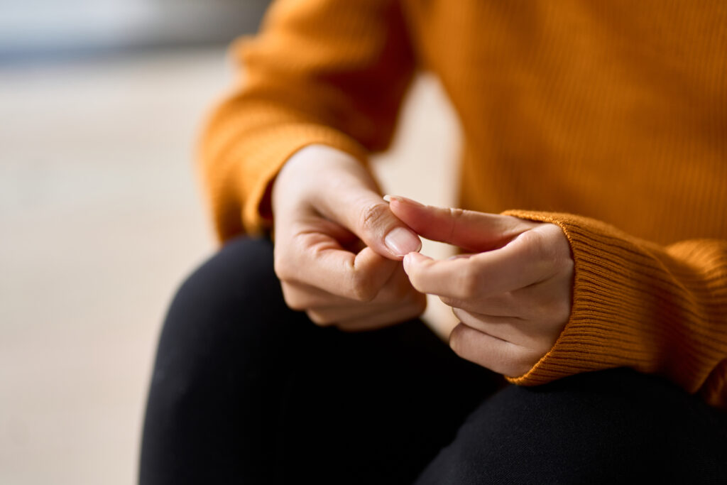 Hands of a woman playing with nails in stress