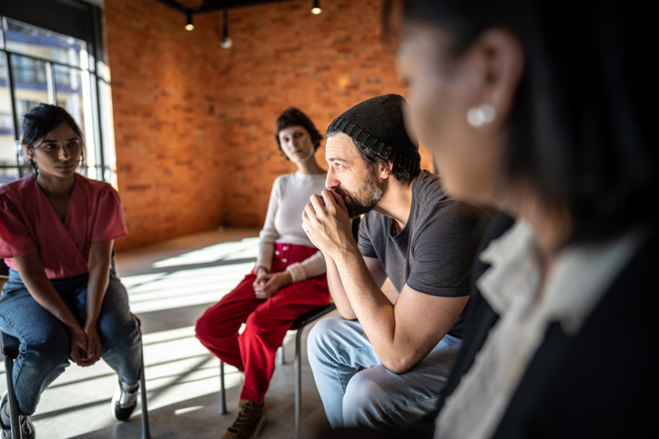 Adult male talking in a group therapy session