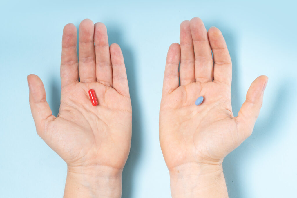 Colorful pills in two hands ober blue. Medical pharmacy ad choise concept.